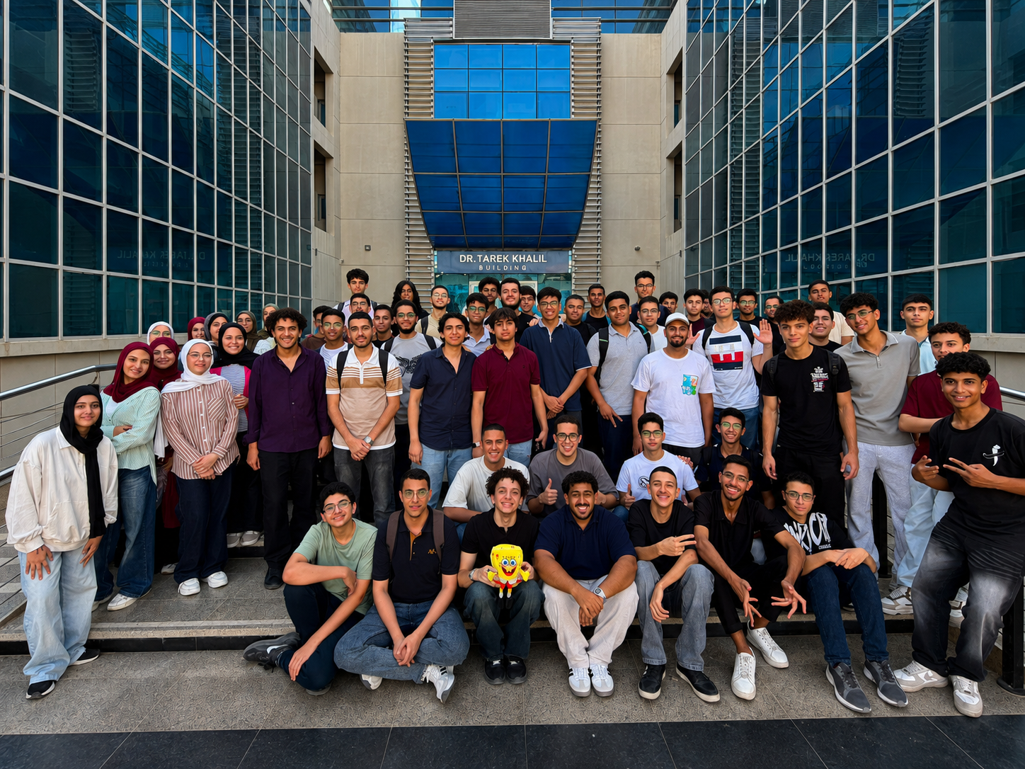 EYCC 2026 Grand Finals group photo featuring all 55 high school student finalists across 15 teams and Mont5ab El2hwa challenge authors outside Dr. Tarek Khalil Building EYCC 2026 Grand Finals group photo featuring all 55 high school student finalists across 15 teams and Mont5ab El2hwa challenge authors outside Dr. Tarek Khalil Building